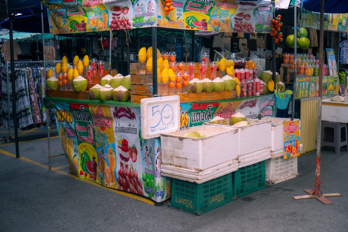 Thai fruit juice market stall with Thai menu banners and handwritten prices
